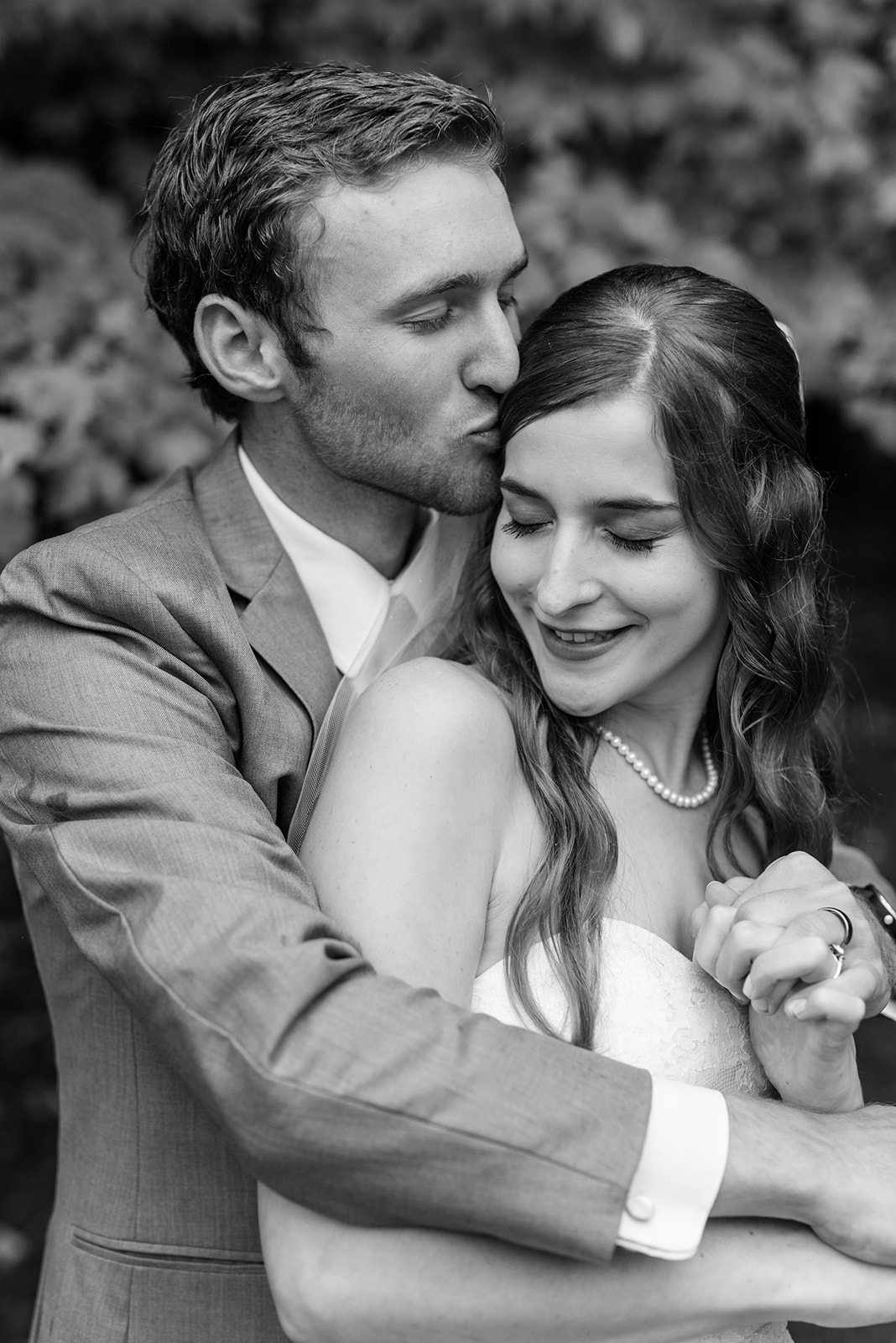 Black and white image of groom and bride kissing on their wedding day
