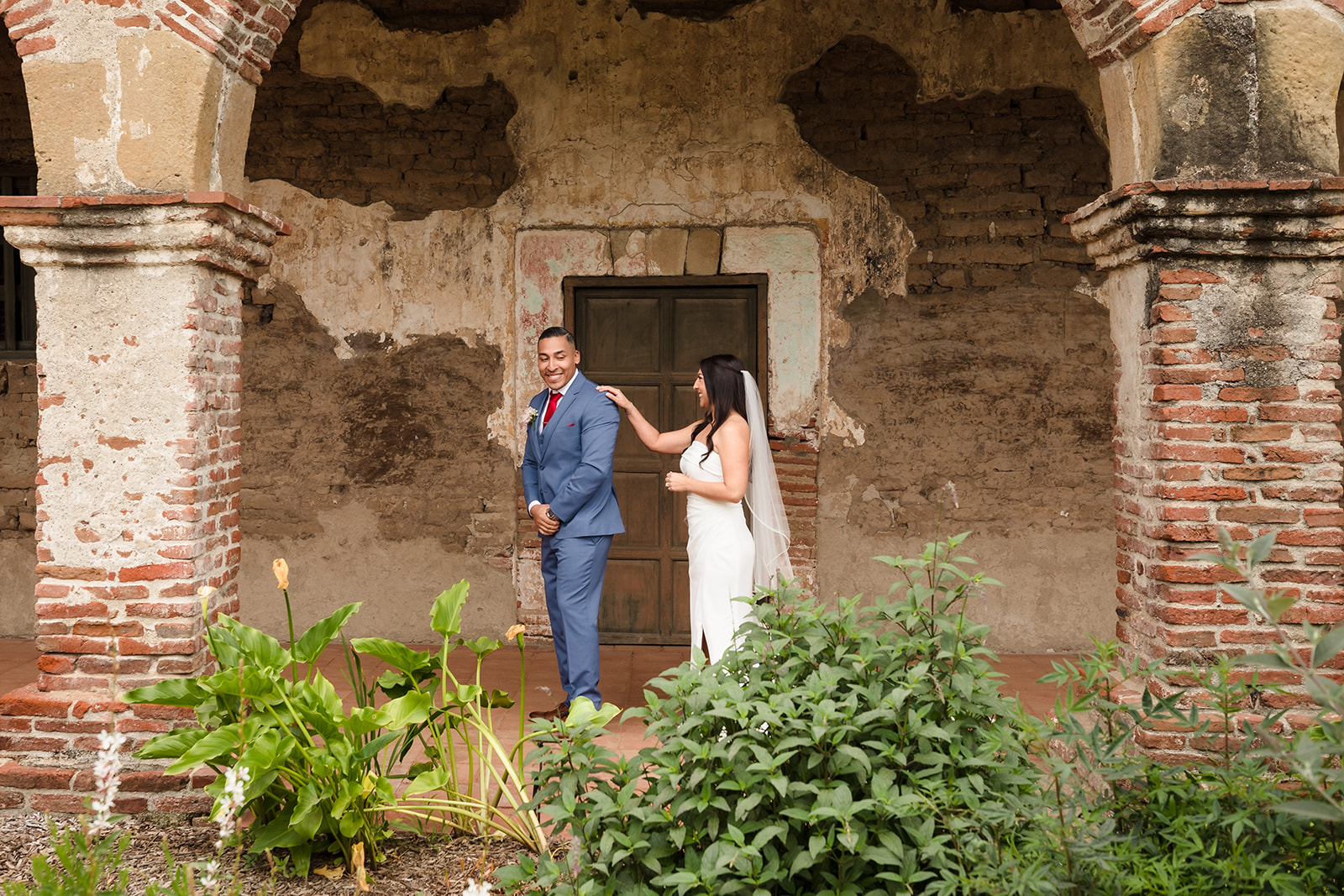 Bride and groom's first look at Mission San Juan Capistrano courtyard