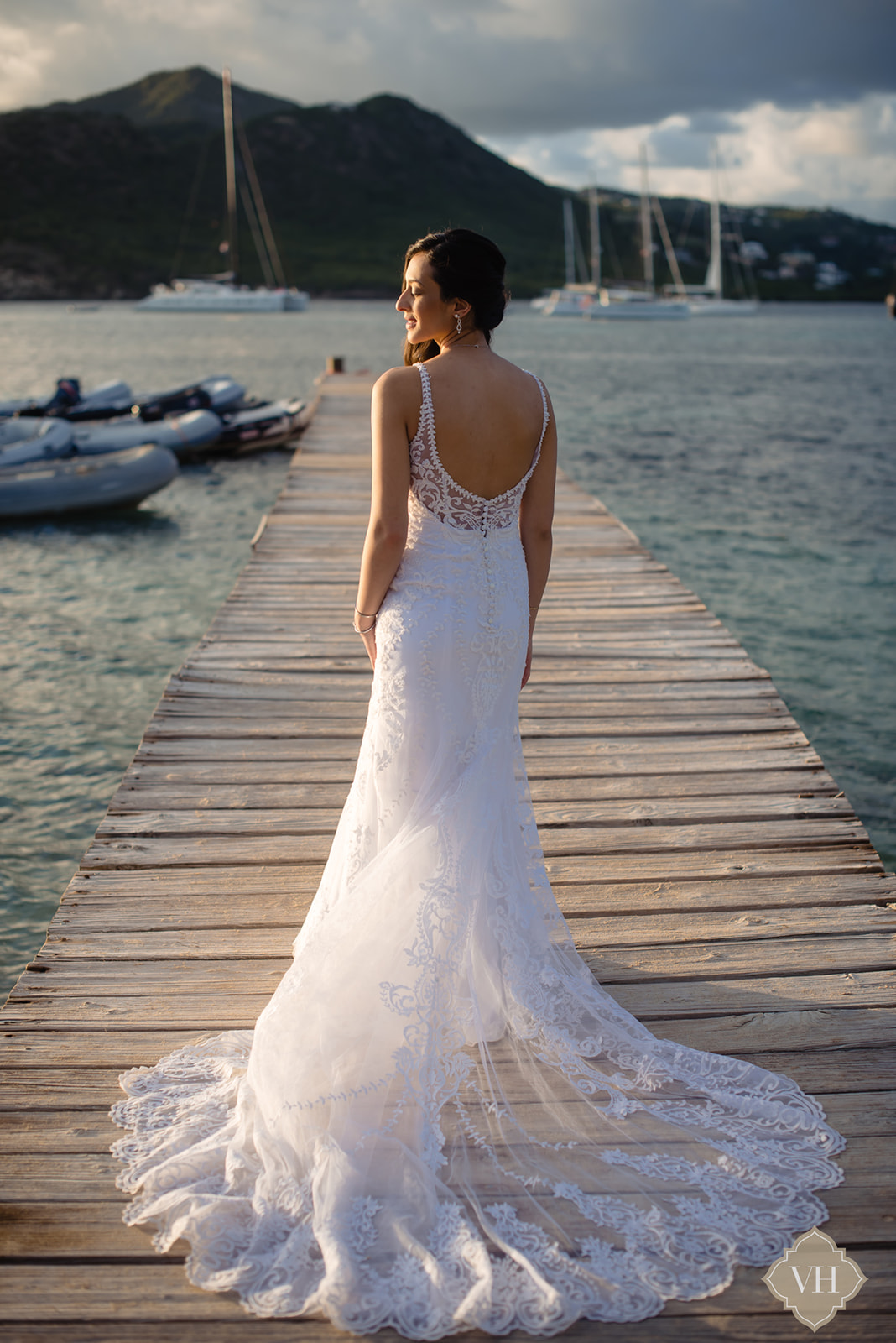 Bride wearing white wedding dress on a wooden dock after her beach wedding on the  island of antigua and barbuda
