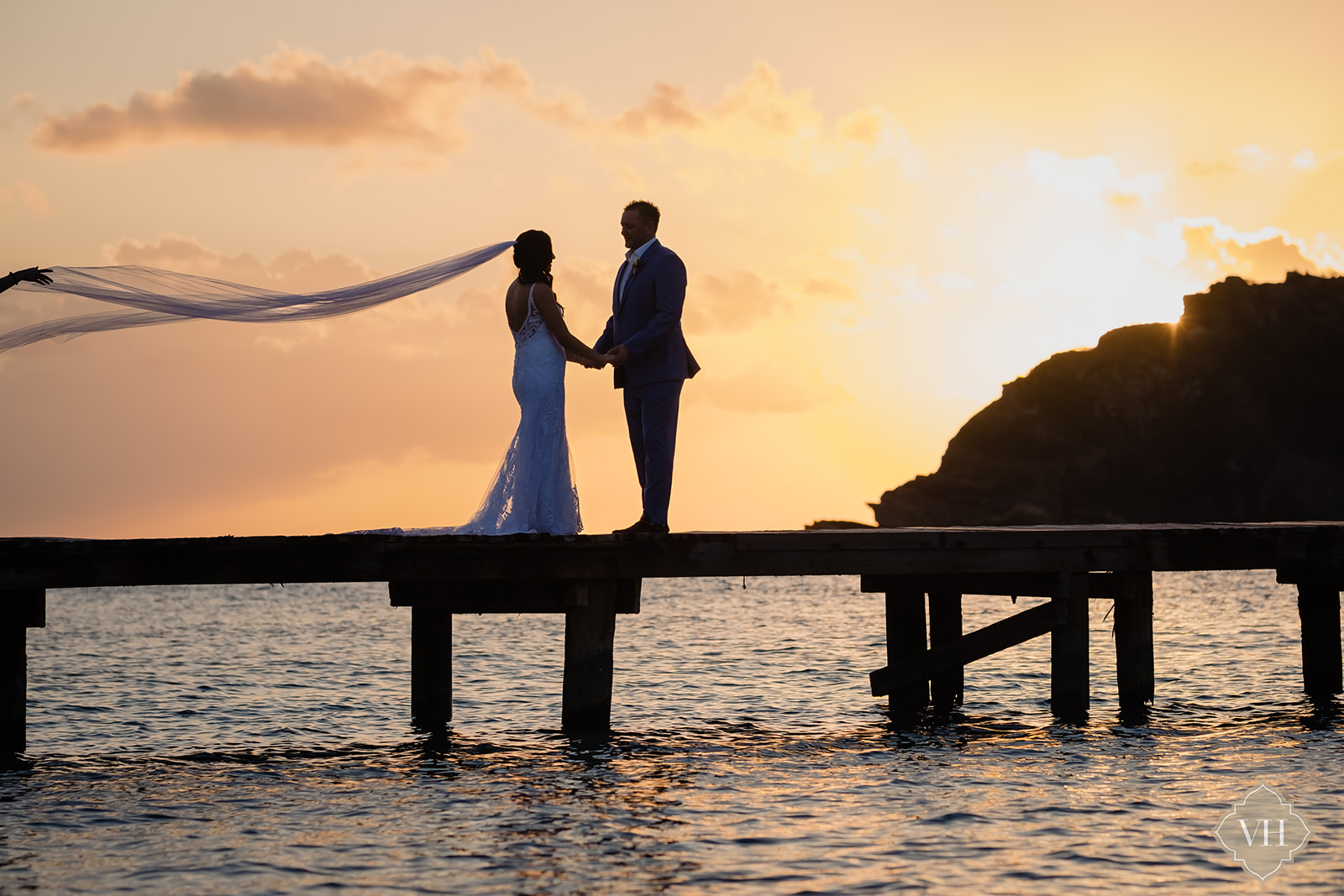 sunset photo of Bride and Groom holding hands on a dock in Antigua and Barbuda
