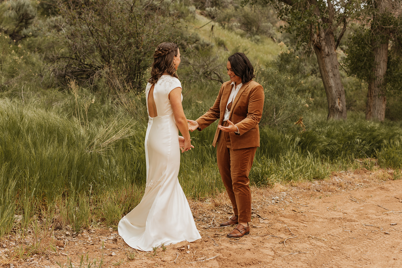 Two brides seeing each other for the first time during their first look 