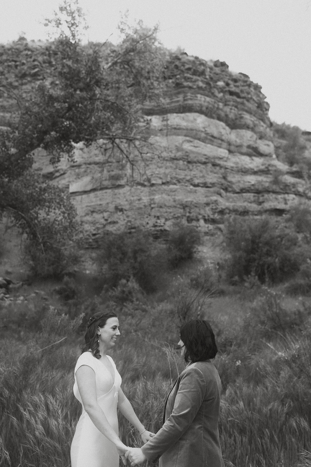 Black and white images of two brides holding hands in front of rocks at Zion National Park 