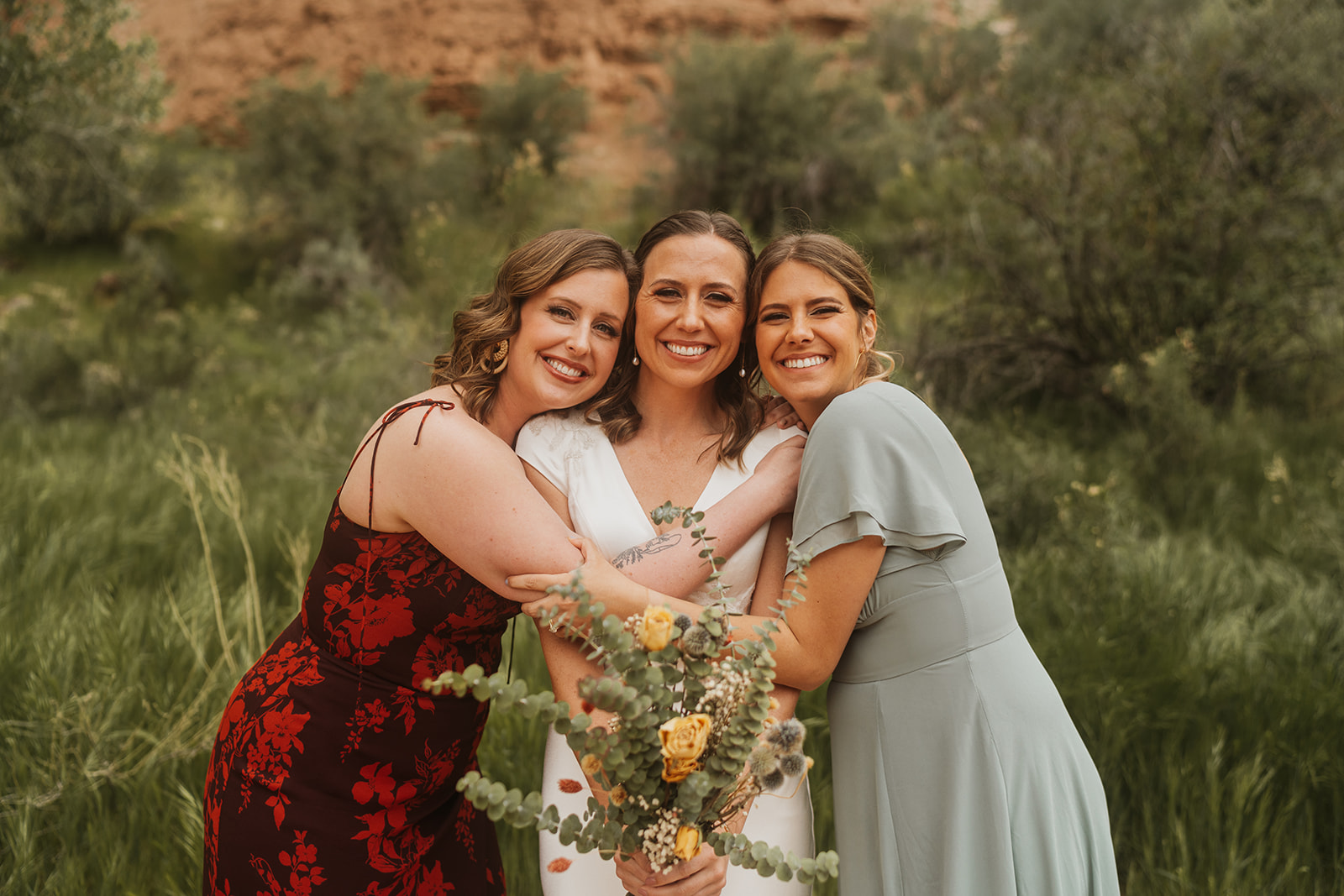 A bride in the center with two bridesmaids on either side 