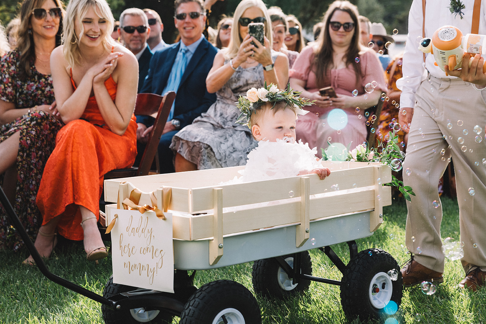 Couple included their baby in the wedding ceremony with an adorable wagon ride and bubbles