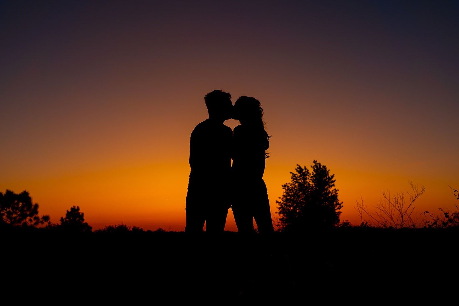 Couple silouehetted by the sun setting at Lake Louisa State Park during birthday photo shoot