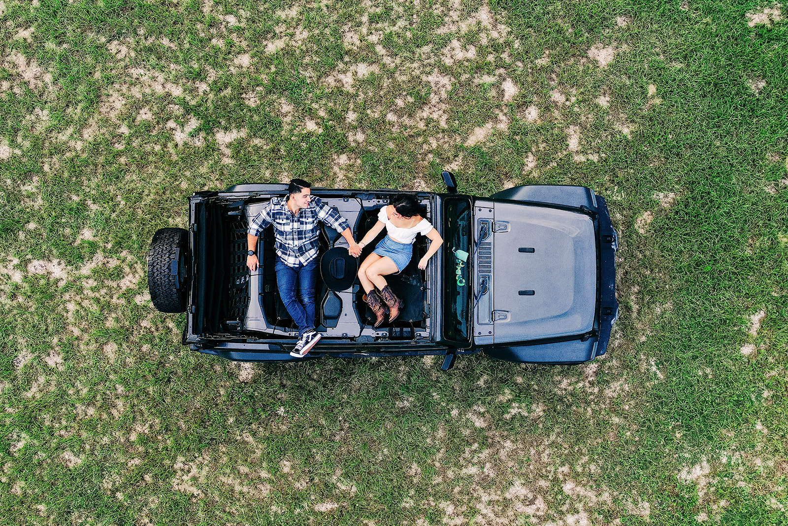 Drone view of couple holding hands during creative and unique Engagement photo session at Bending Branch Ranch