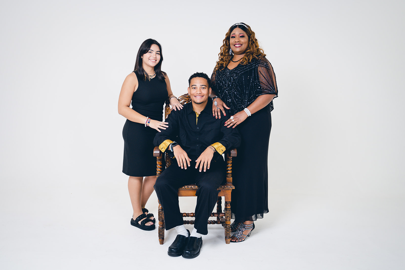 Mother, son, & girlfriend pose against a white, indoor studio wall during family photo session at Orlando Rental Studio.
