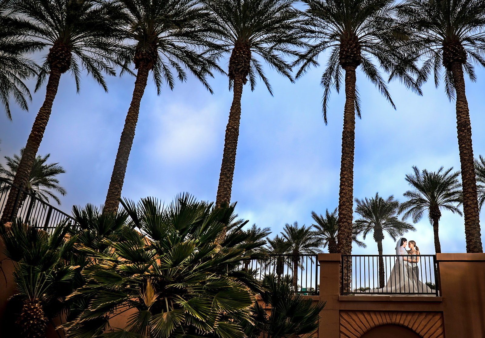 Two brides among palm trees at their wedding in Las Vegas