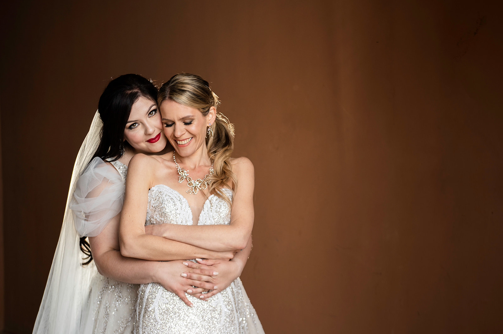 Two brides embracing in color photo in Las Vegas