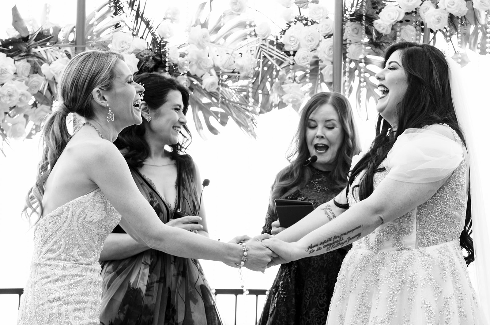 BW storytelling photo of same-sex wedding ceremony in Las Vegas with brides laughing