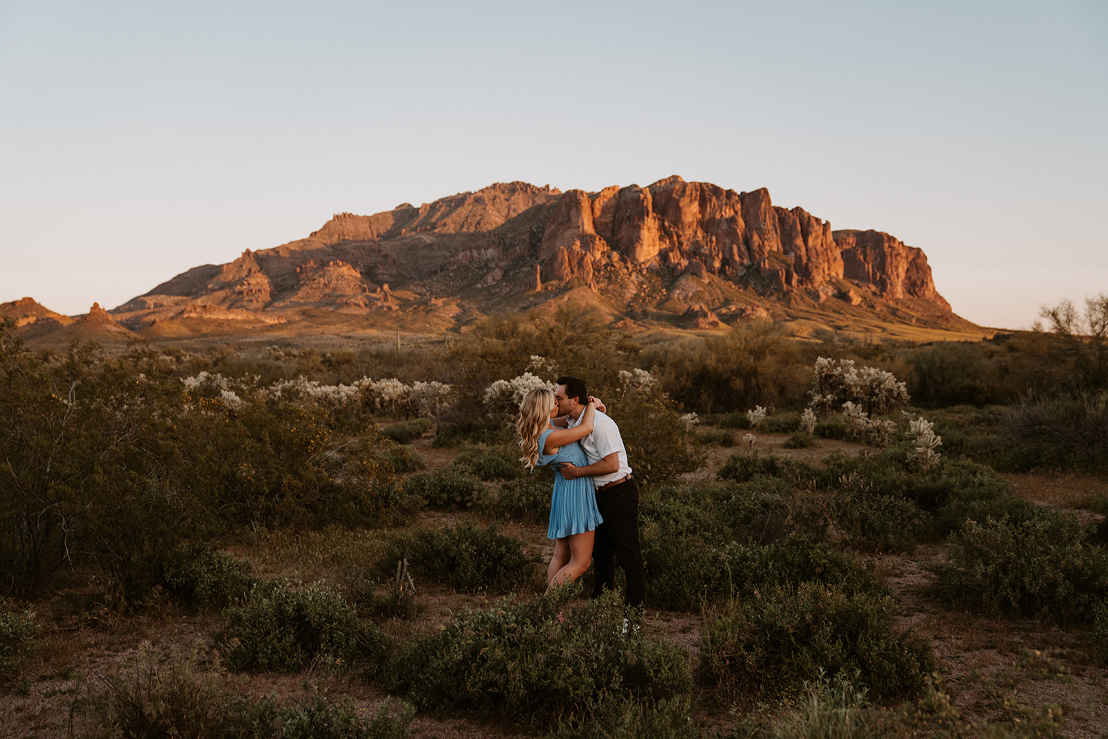 Lost Dutchman State Park, engagement photos showcase the couple's candid moments against vibrant wildflowers.