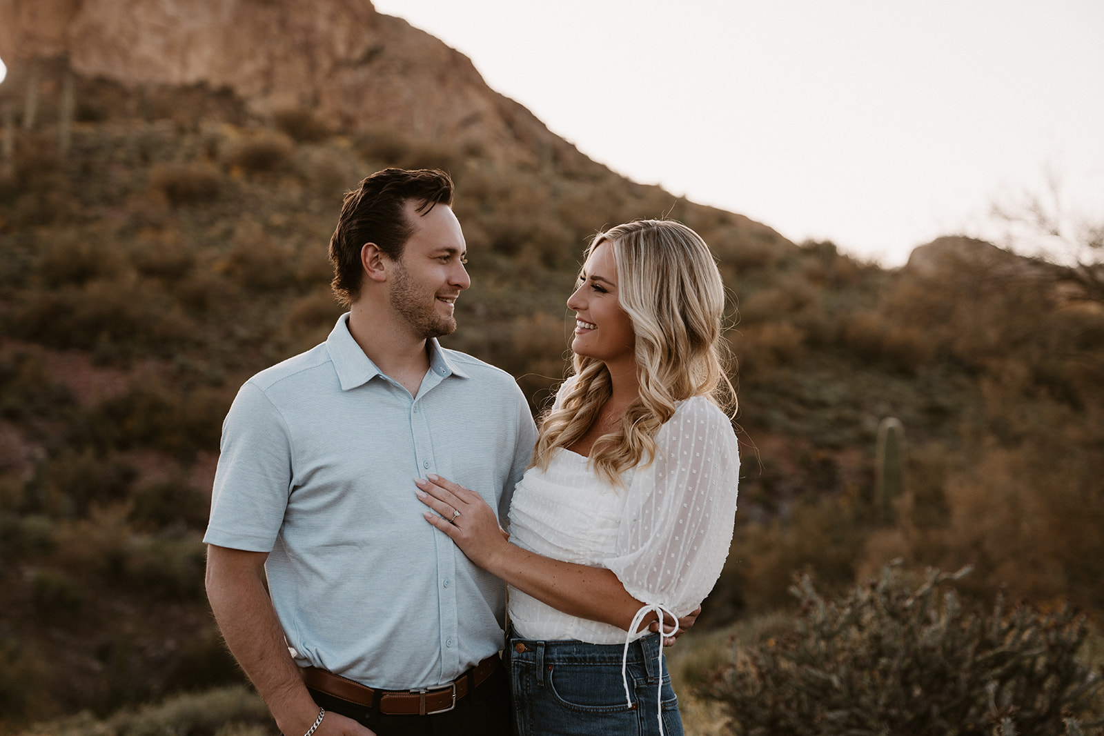 Lost Dutchman State Park, engagement photos showcase the couple's candid moments against vibrant wildflowers.