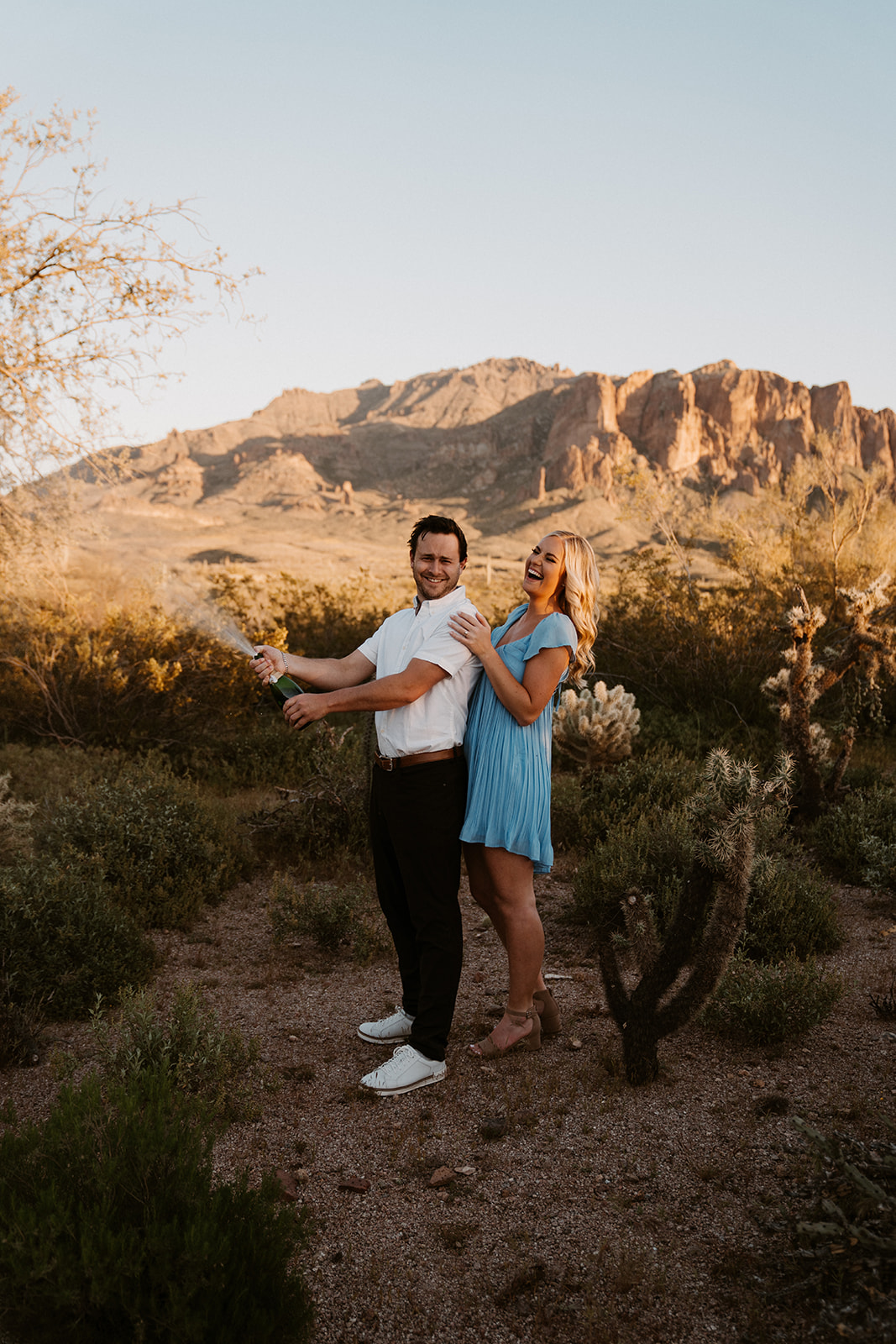 Popping champagne for engagement photos in the Phoenix Arizona Desert