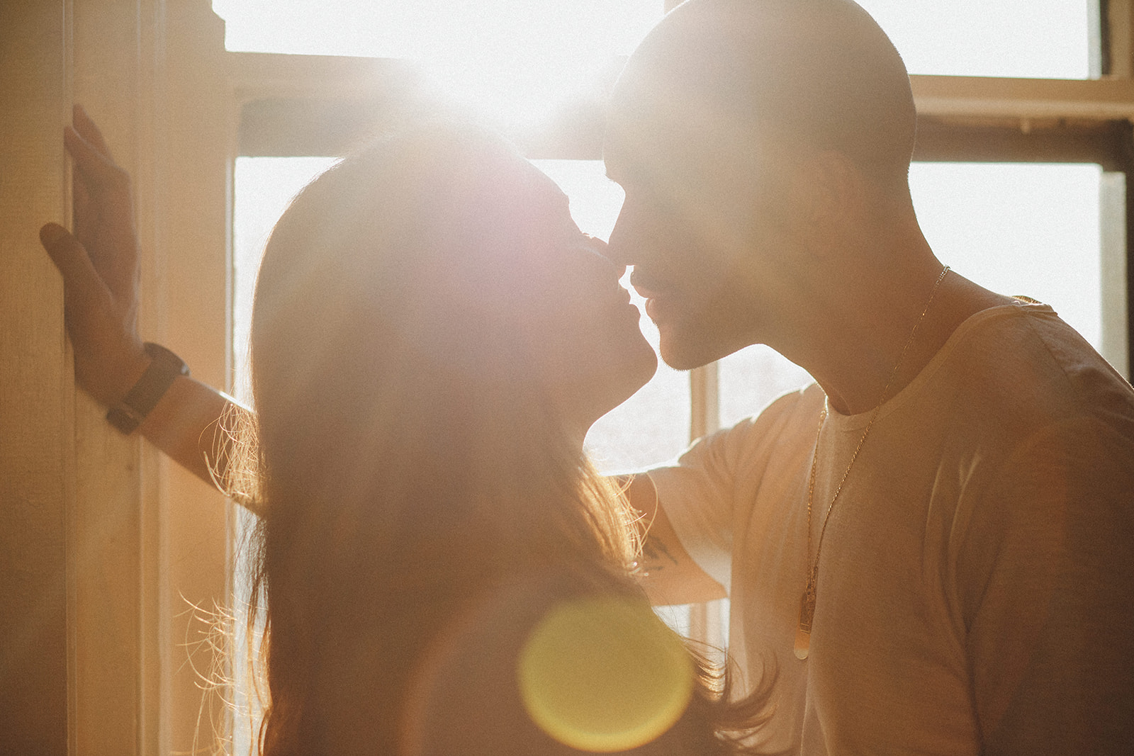 A couple shares a sweet kiss as the sun pours into their office of their downtown Cincinnati condo