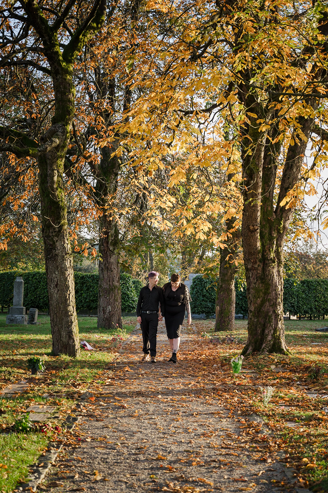 engaged couple walking through cemetery
