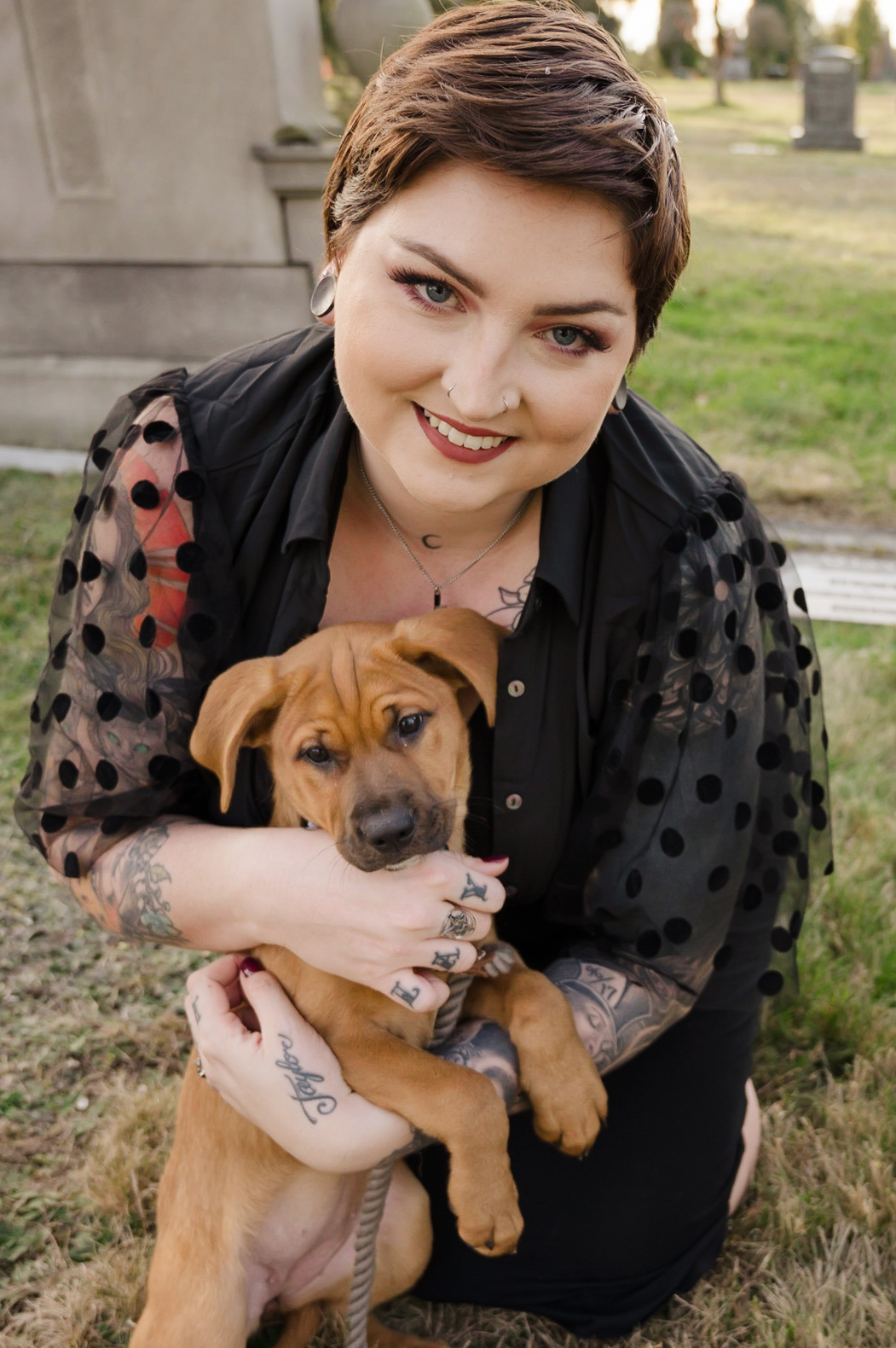 engagement photo of bride-to-be playing with puppy in a cemetery