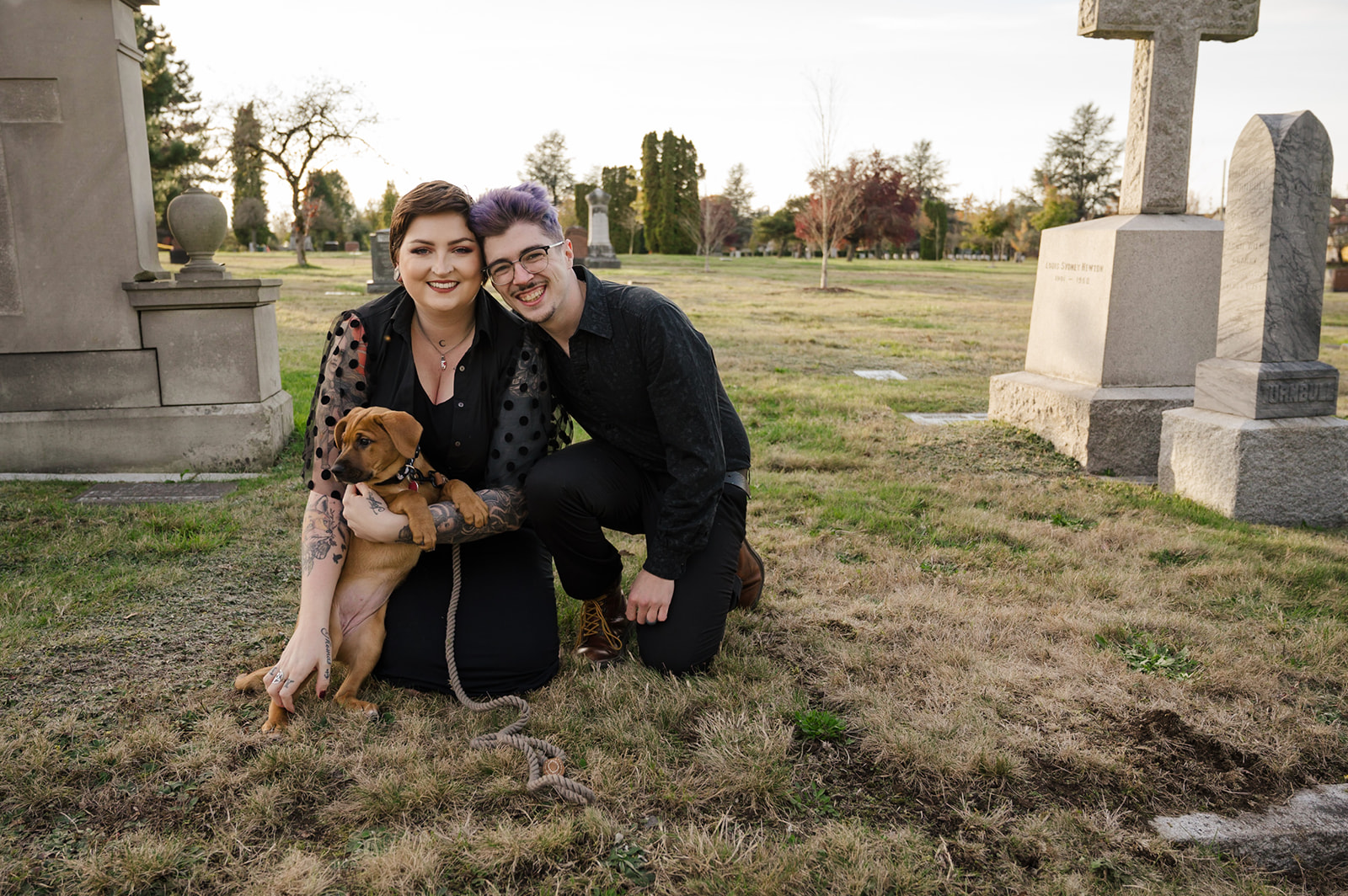 engagement photo of couple with puppy in cemetery