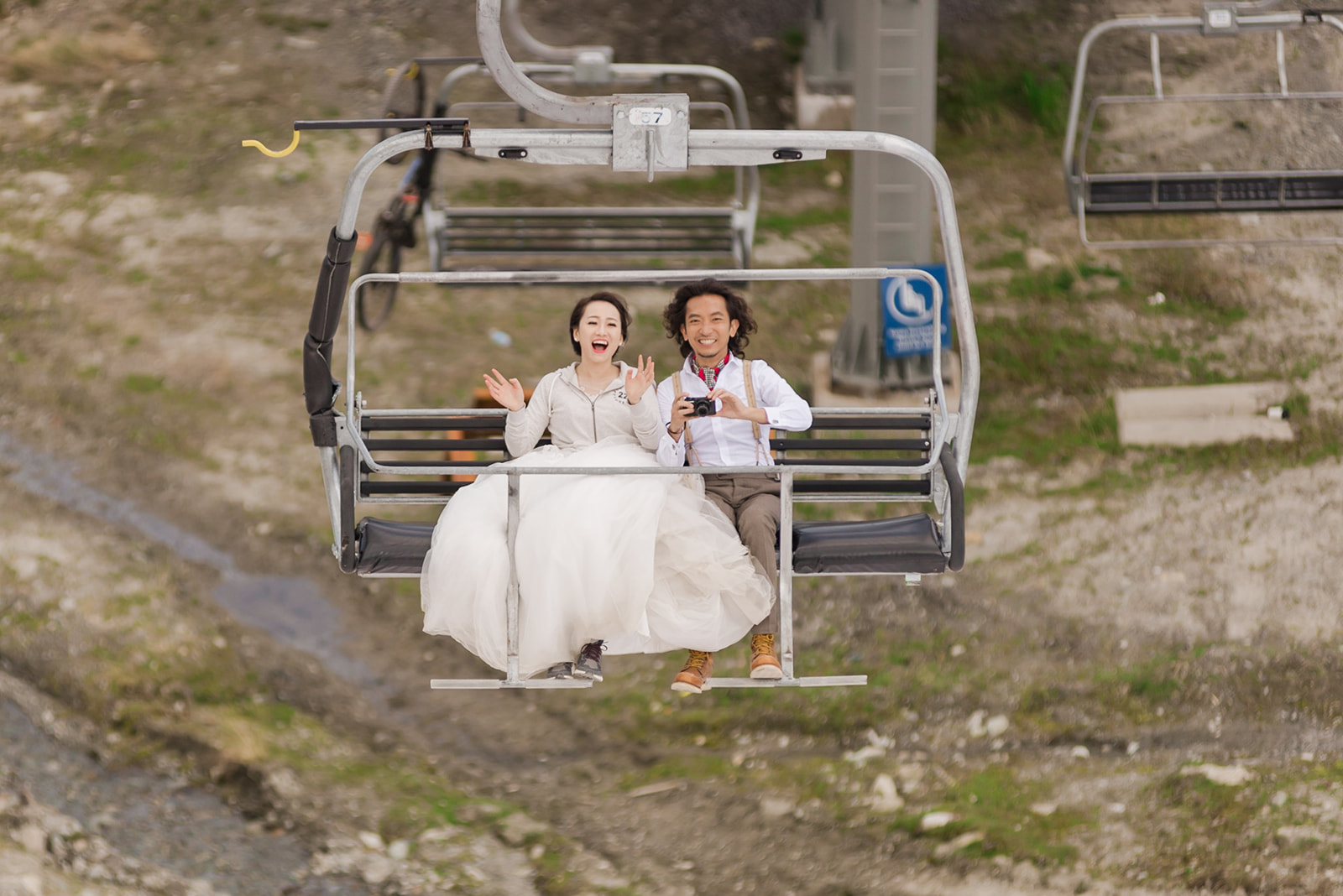 couple taking a chairlift to the top of a mountain on a hiking elopement