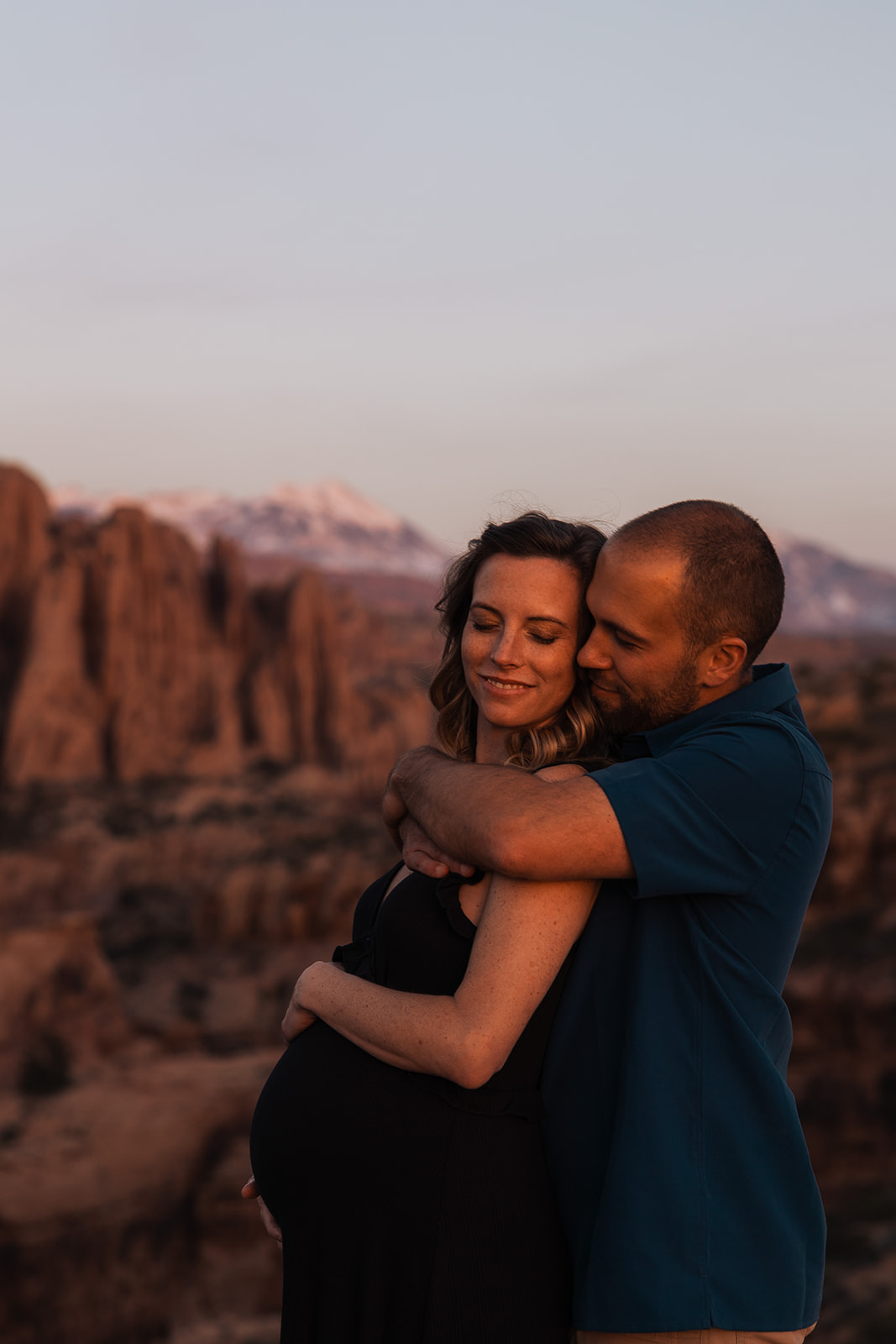 adventurous couple hikes for maternity portraits in the moab utah desert